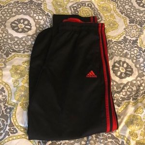 Men’s black and red adidas pants.